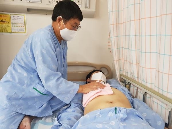 밀알사랑의집 사회복지사 손희근씨(58)가 같은 병원에 입원 중인 한 장애인을 돌보고 있다. (칠곡군 제공)